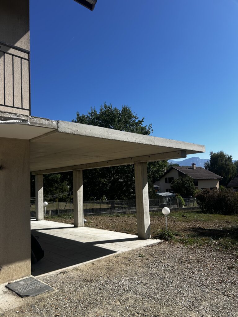 Terrasse surélevée portée par des poteaux en béton armé, vue de dessous
