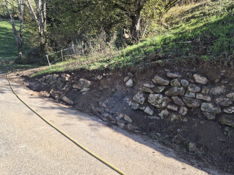 Pied du mur nettoyé, pierres déchaussées visibles