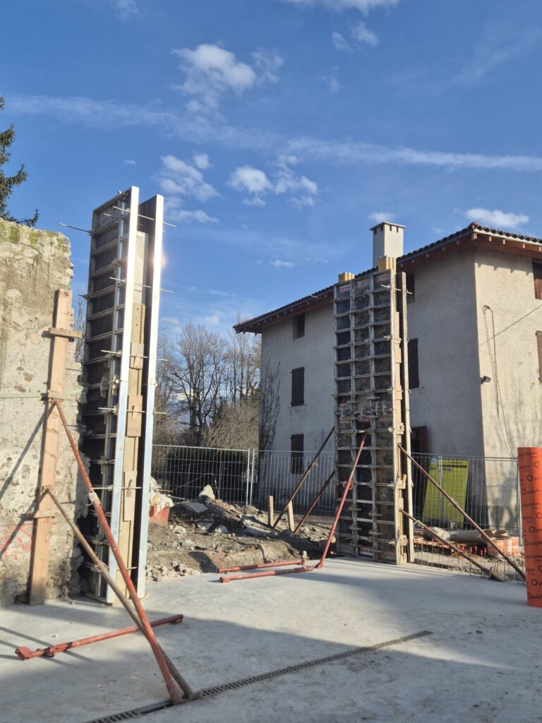 Coffrage d'un poteau en béton armé contre le pignon