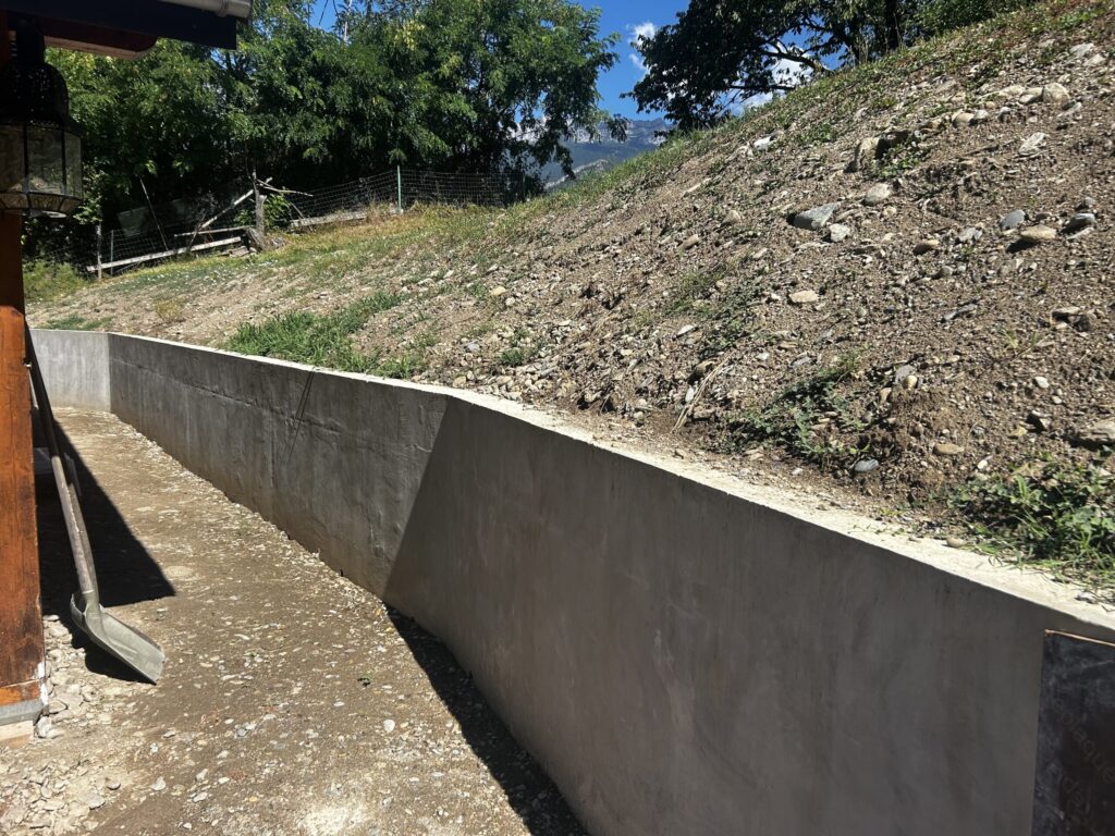 Mur de soutènement terminé, terre replacée contre l'ouvrage