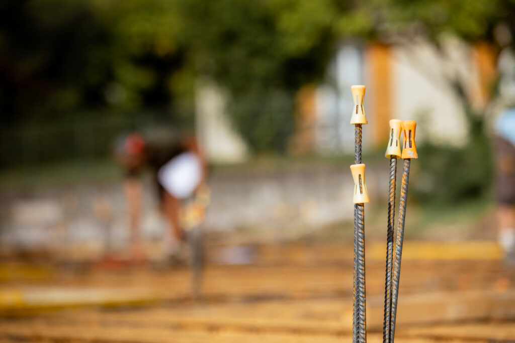 Maçon au travail sur un chantier, armatures en attente